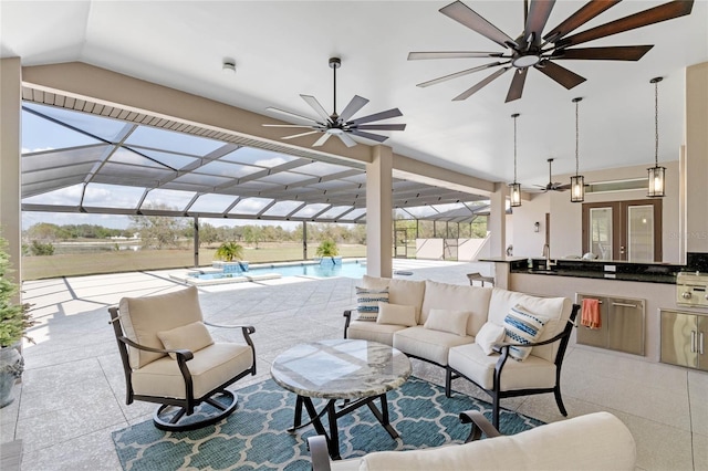 view of patio with an outdoor hangout area, a ceiling fan, glass enclosure, exterior kitchen, and an outdoor pool