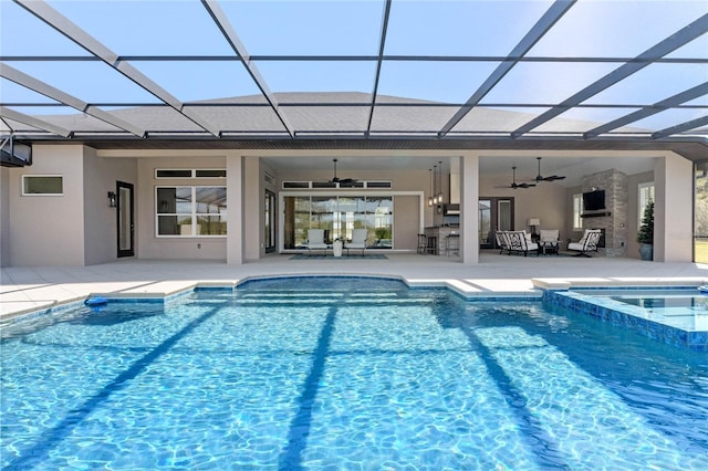 view of pool with a lanai, a pool with connected hot tub, a ceiling fan, and a patio