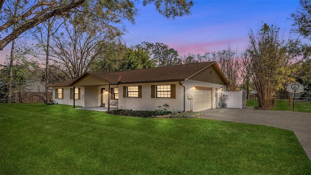 ranch-style home with an attached garage, fence, driveway, stucco siding, and a front yard