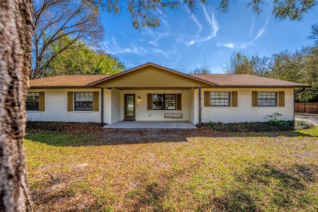 single story home featuring a front lawn, fence, and stucco siding