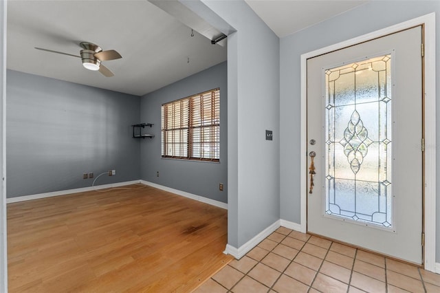 foyer with light wood-style floors, ceiling fan, and baseboards