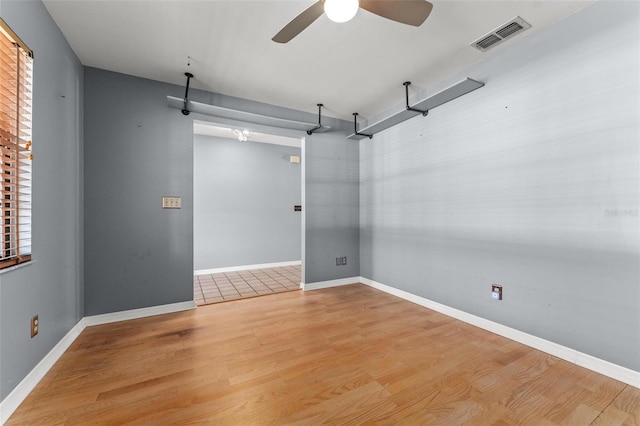 unfurnished room featuring baseboards, visible vents, and wood finished floors