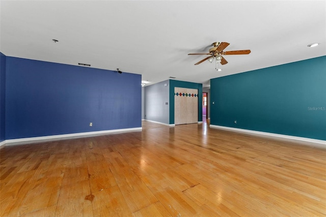 unfurnished living room with ceiling fan, visible vents, light wood-style flooring, and baseboards