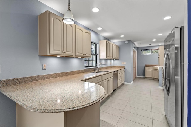 kitchen featuring pendant lighting, recessed lighting, appliances with stainless steel finishes, a sink, and a peninsula