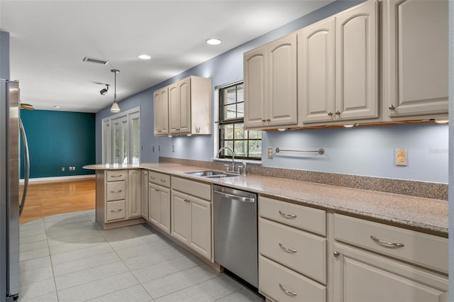 kitchen featuring recessed lighting, light countertops, appliances with stainless steel finishes, a sink, and a peninsula