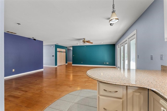 kitchen with decorative light fixtures, light wood finished floors, open floor plan, ceiling fan, and baseboards