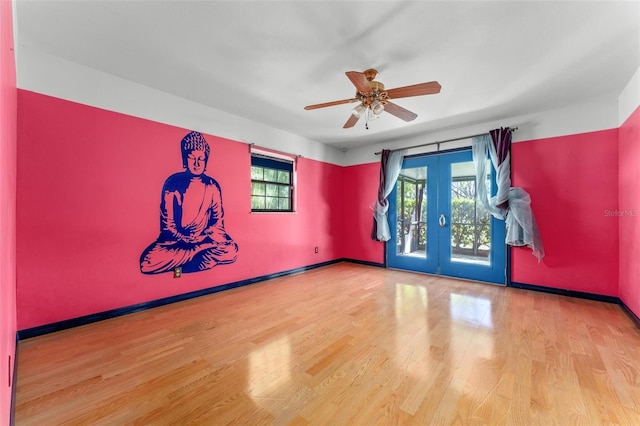 spare room with a ceiling fan, baseboards, wood finished floors, and french doors