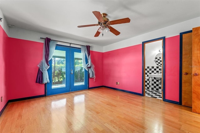 unfurnished room featuring french doors, ceiling fan, baseboards, and wood finished floors