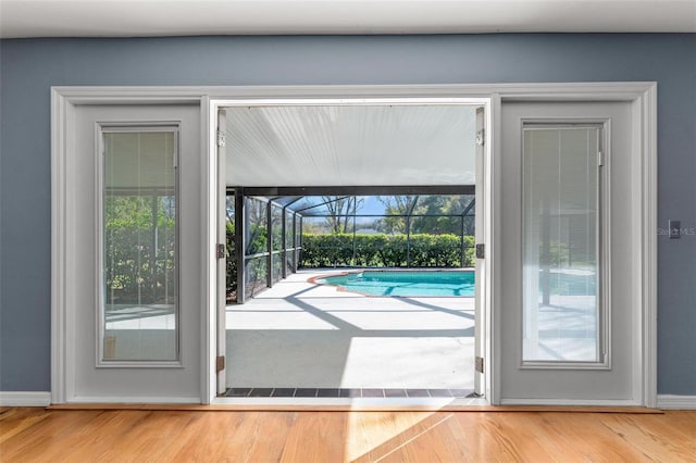 doorway to outside with wood finished floors and a sunroom