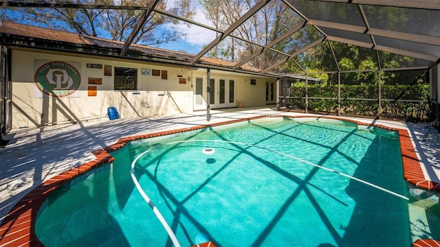 outdoor pool featuring a lanai, a patio area, and french doors