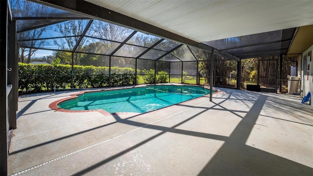 outdoor pool with glass enclosure and a patio area