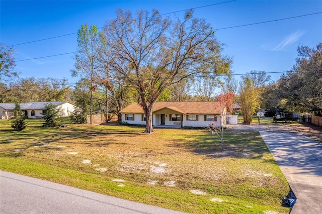 view of front facade featuring fence, a front lawn, and concrete driveway