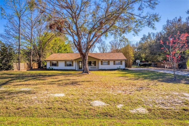 ranch-style house with fence and a front lawn