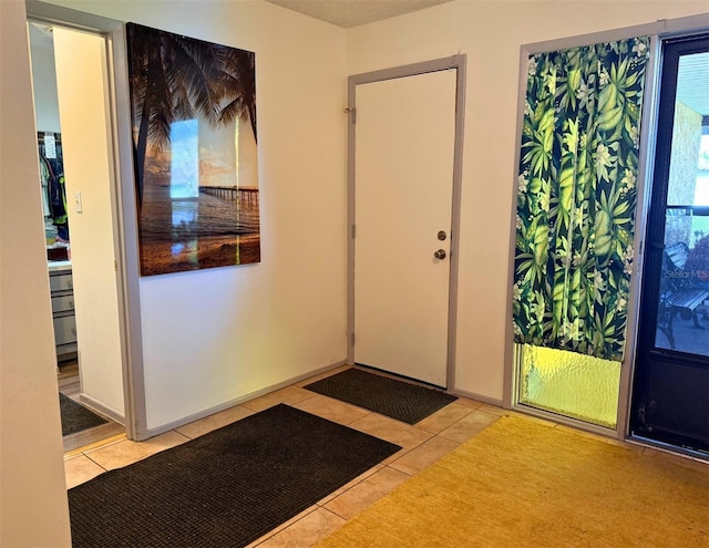 foyer with light tile patterned flooring and baseboards