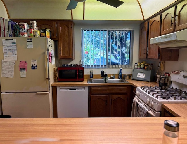 kitchen featuring ceiling fan, under cabinet range hood, white appliances, a sink, and light countertops