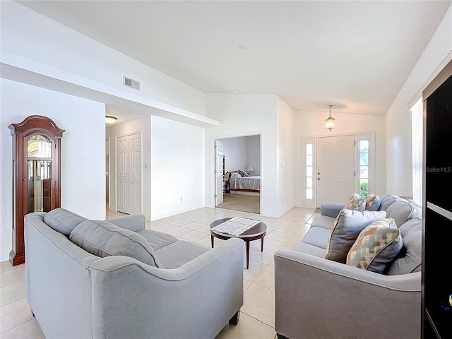 living room with vaulted ceiling, light tile patterned flooring, a healthy amount of sunlight, and visible vents