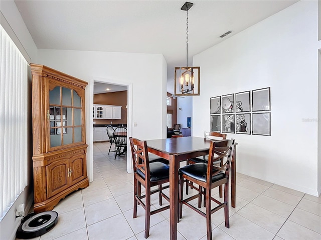 dining room featuring light tile patterned floors, visible vents, a chandelier, and lofted ceiling