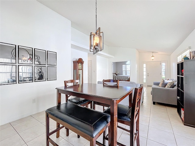 dining room with light tile patterned flooring, an inviting chandelier, and lofted ceiling