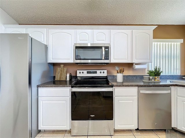 kitchen with dark countertops, appliances with stainless steel finishes, and white cabinetry