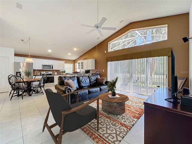 living area featuring light tile patterned floors, high vaulted ceiling, a textured ceiling, and a ceiling fan