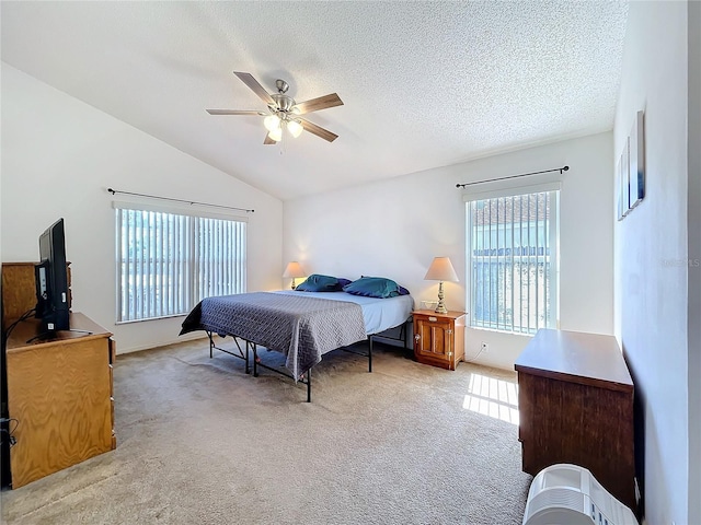 bedroom with multiple windows, light colored carpet, lofted ceiling, and a textured ceiling