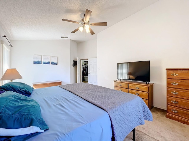 bedroom featuring light carpet, a textured ceiling, a ceiling fan, and vaulted ceiling