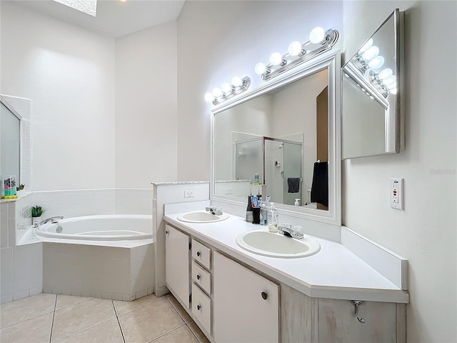 full bath with tile patterned floors, a stall shower, a garden tub, and a sink