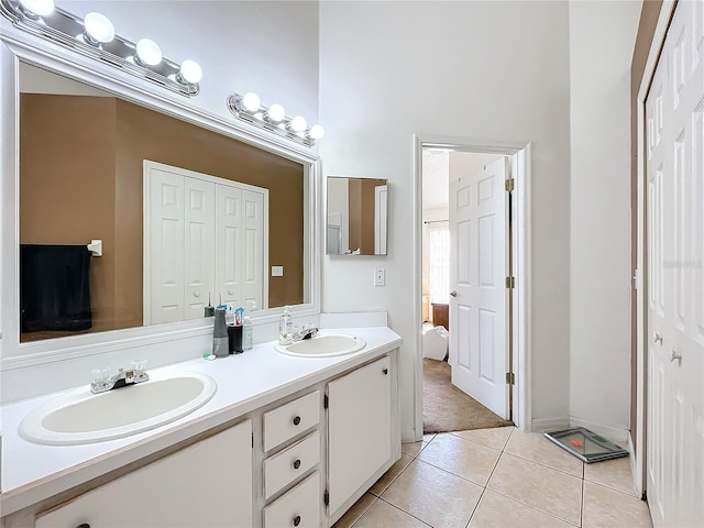 full bath with tile patterned floors, double vanity, and a sink