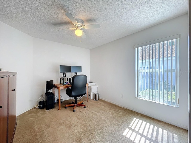 carpeted home office with baseboards, a textured ceiling, and ceiling fan