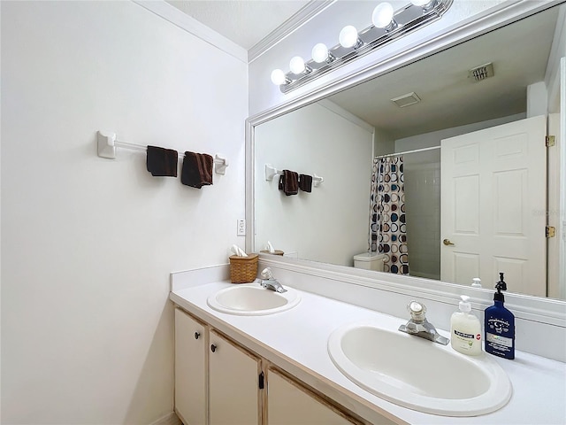 bathroom with double vanity, toilet, visible vents, and a sink