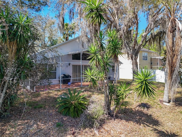 back of property featuring fence and a sunroom