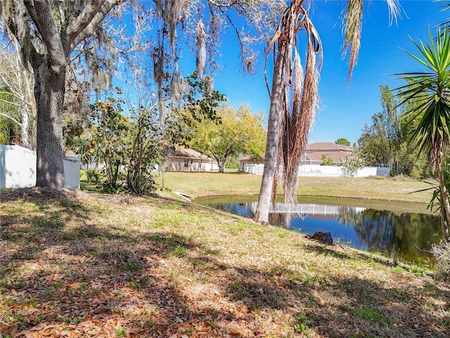 view of yard featuring a water view and fence