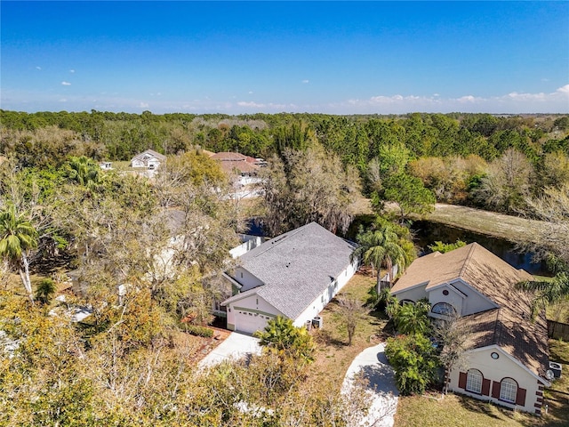 birds eye view of property featuring a forest view