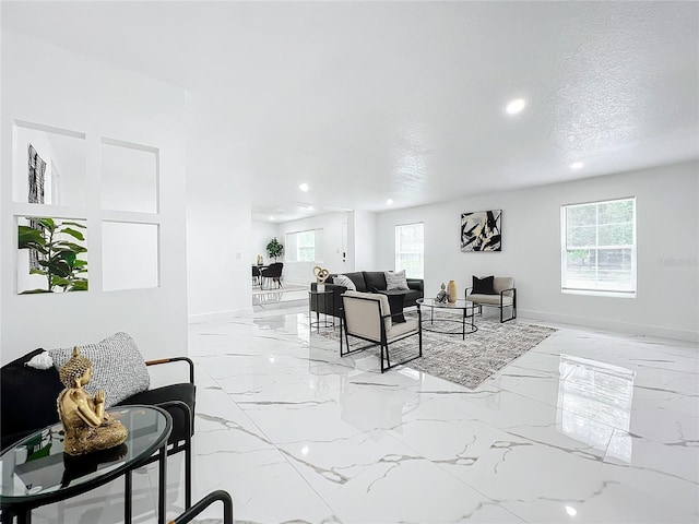 living area featuring a textured ceiling, marble finish floor, recessed lighting, and baseboards