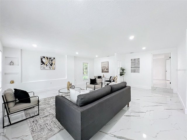 living area featuring recessed lighting, marble finish floor, a textured ceiling, and baseboards