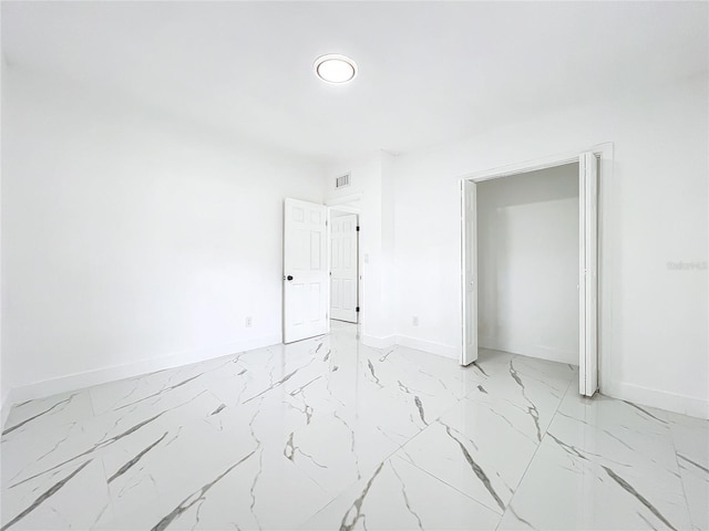 unfurnished bedroom featuring marble finish floor, visible vents, and baseboards