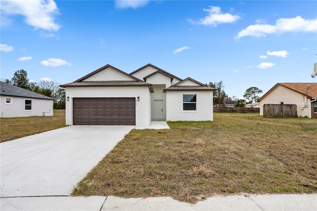 view of front of property with an attached garage, fence, a front lawn, and concrete driveway