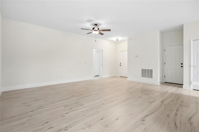 empty room with light wood-style flooring, visible vents, ceiling fan, and baseboards