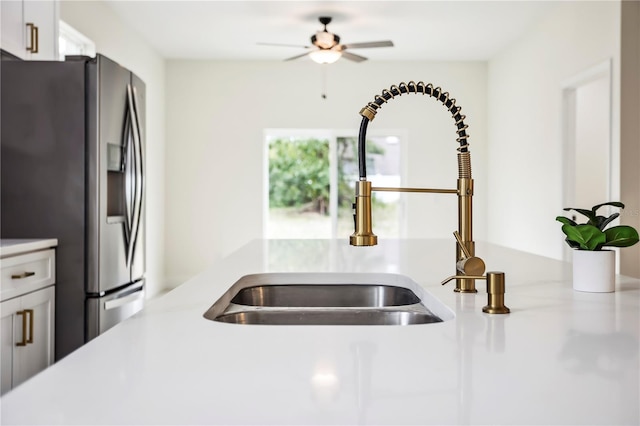 room details featuring light countertops, white cabinets, a sink, ceiling fan, and stainless steel fridge with ice dispenser