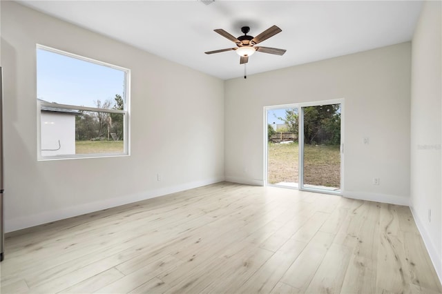 empty room with visible vents, ceiling fan, baseboards, and wood finished floors