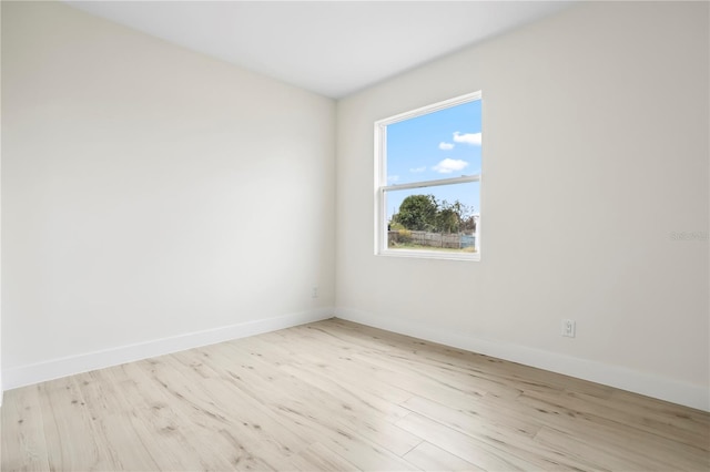 unfurnished room with baseboards and wood finished floors