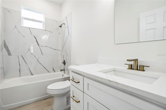 bathroom featuring wood finished floors, tub / shower combination, vanity, and toilet