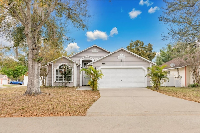 ranch-style house featuring a front yard, an attached garage, and driveway