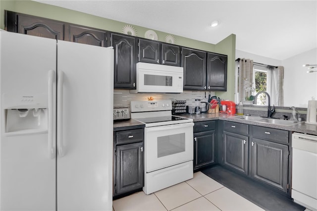 102 Ethan Ave, Davenport, FL 33897 - kitchen featuring white appliances, light tile patterned floors, decorative backsplash, dark countertops, and recessed lighting