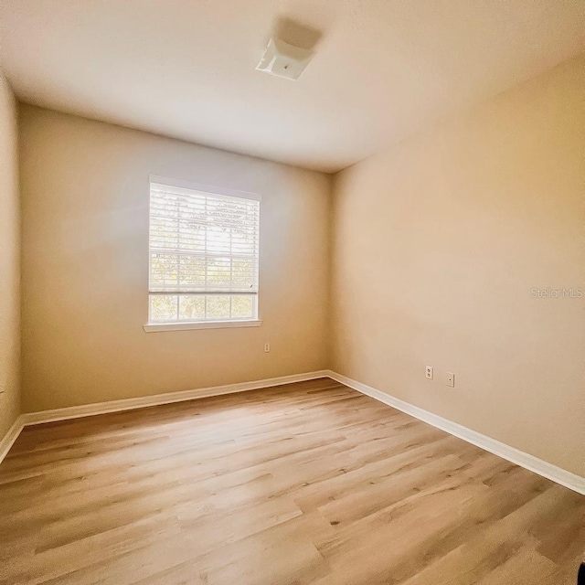 spare room with light wood-style flooring and baseboards