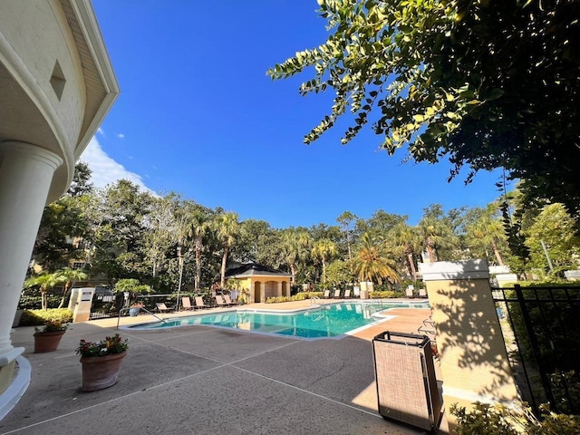 community pool featuring a patio area and fence