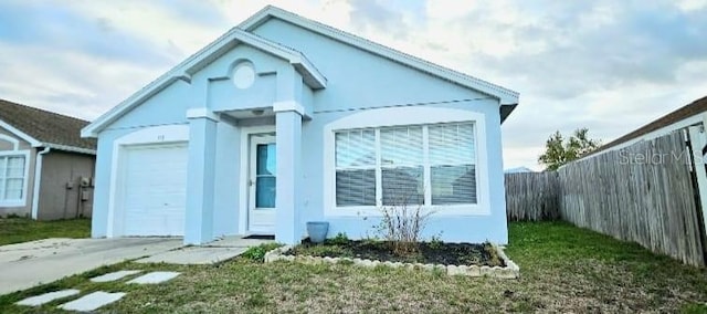 view of front facade featuring an attached garage, fence, and stucco siding