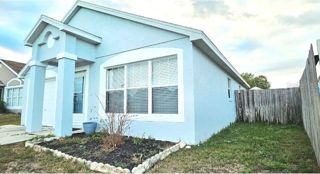 view of property exterior featuring fence and stucco siding