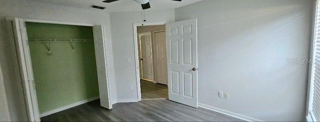 unfurnished bedroom featuring a closet, visible vents, baseboards, and wood finished floors