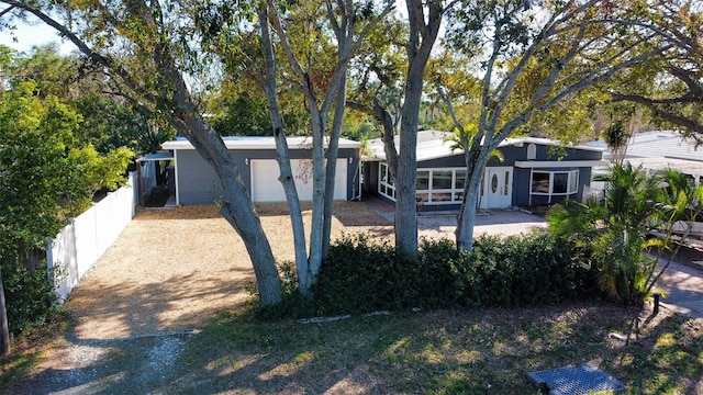 view of front of property featuring an attached garage and fence